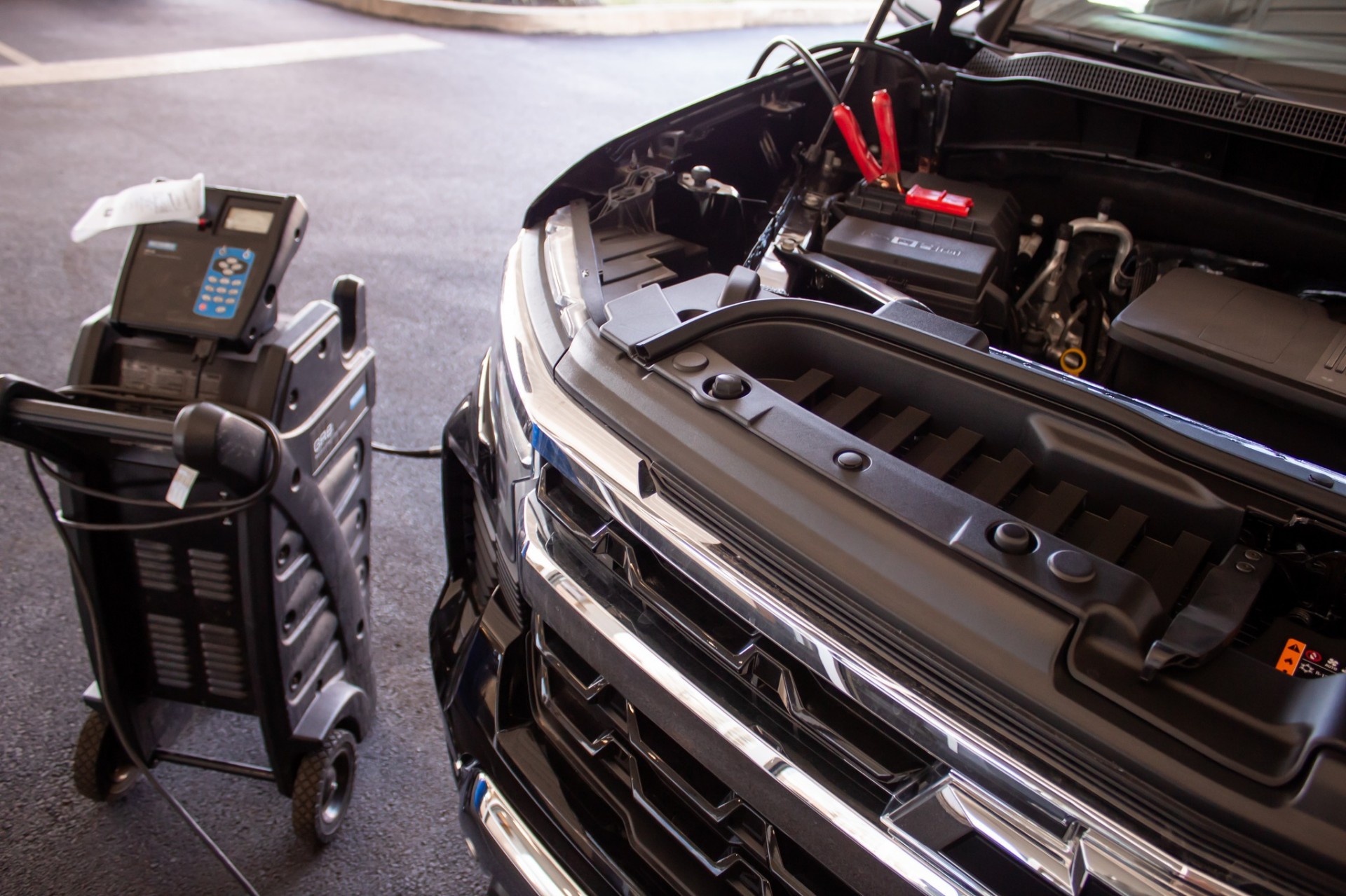 Technician diagnosing a truck in a dealership service bay.