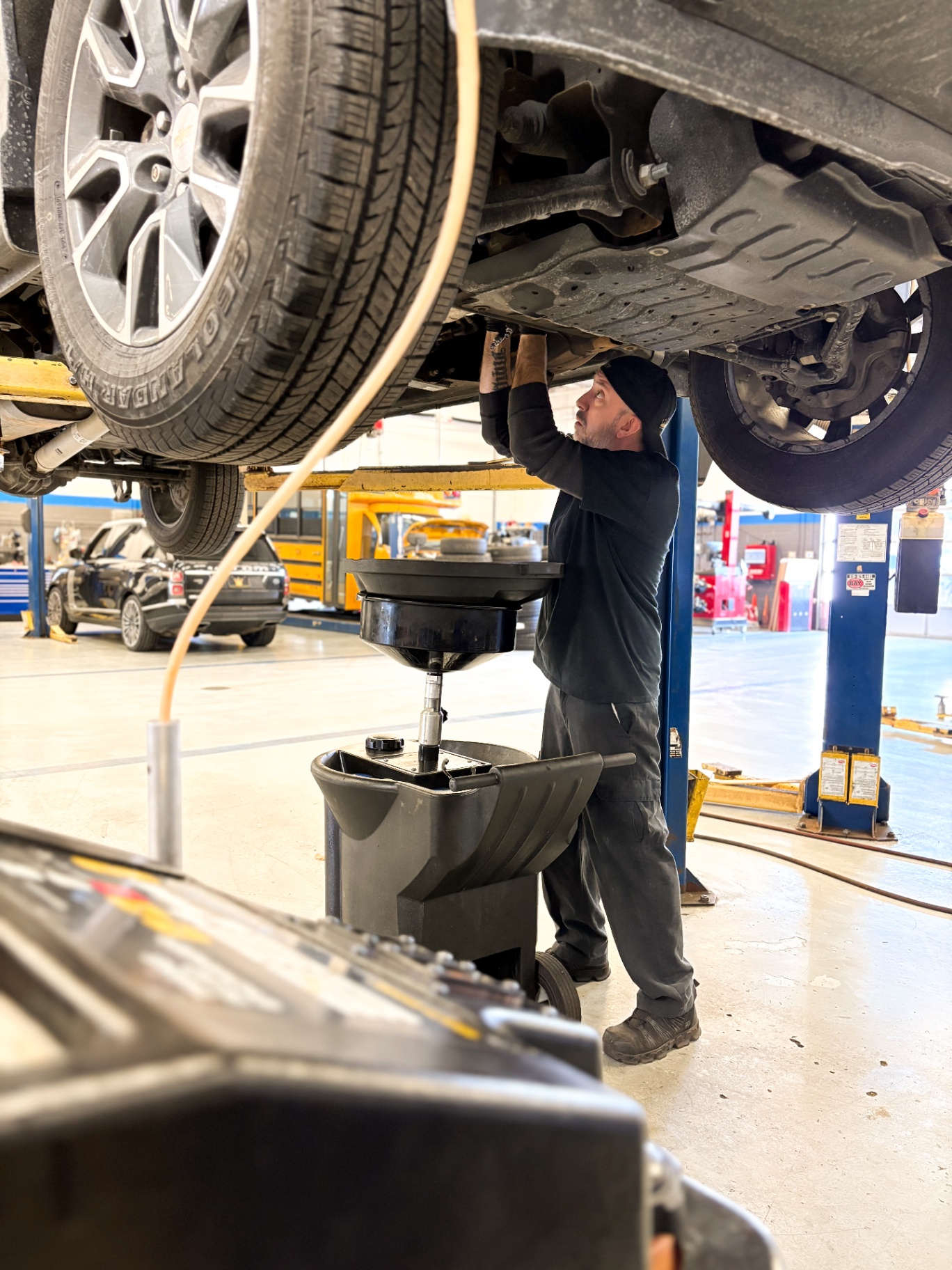 Patriot technician performing an oil change on a Chevrolet on the lift