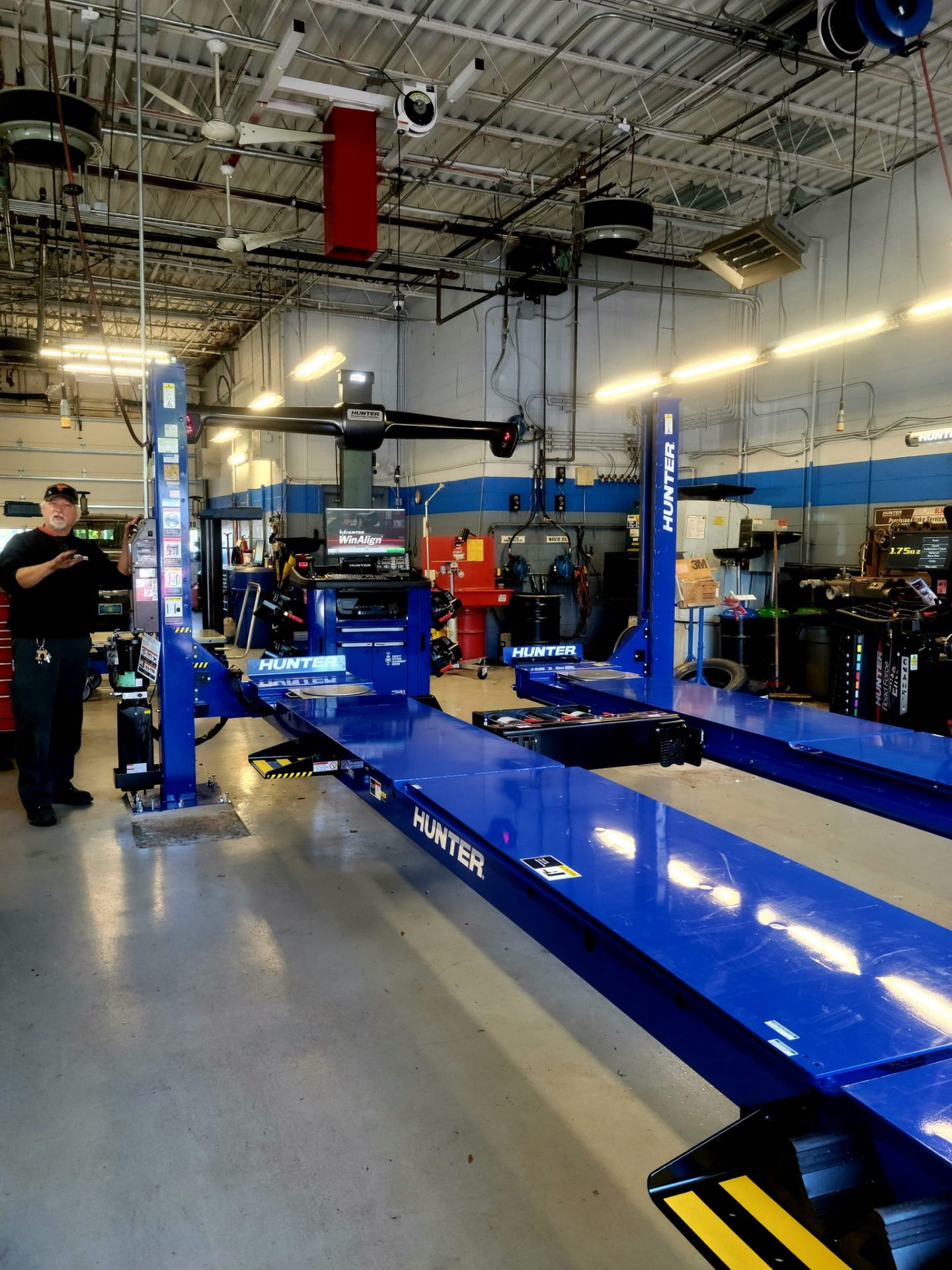 Technician performing an alignment on a vehicle at a service shop.