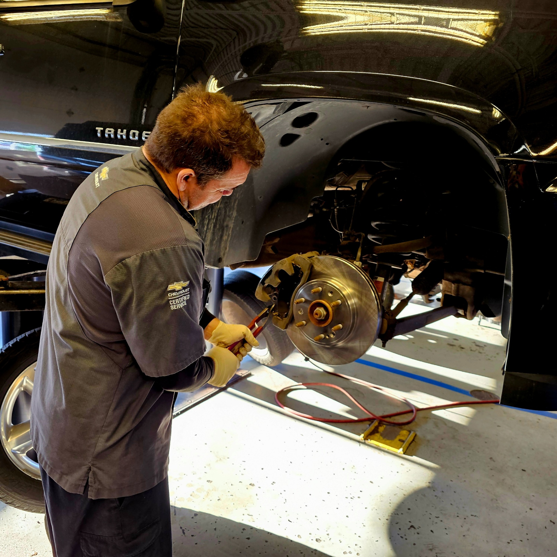 Patriot Chevrolet Certified Service tech performing brake work on a Tahoe